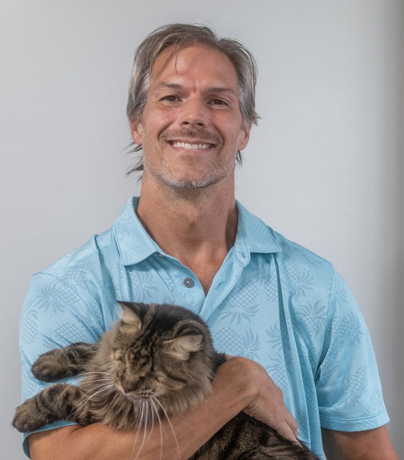 Josh Ribbeck holding Echo, his blind long-haired tabby cat